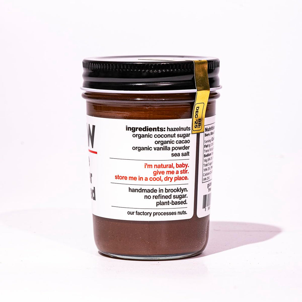 Fine & Raw opened jar with spoon highlighting creamy spreadable texture and richness