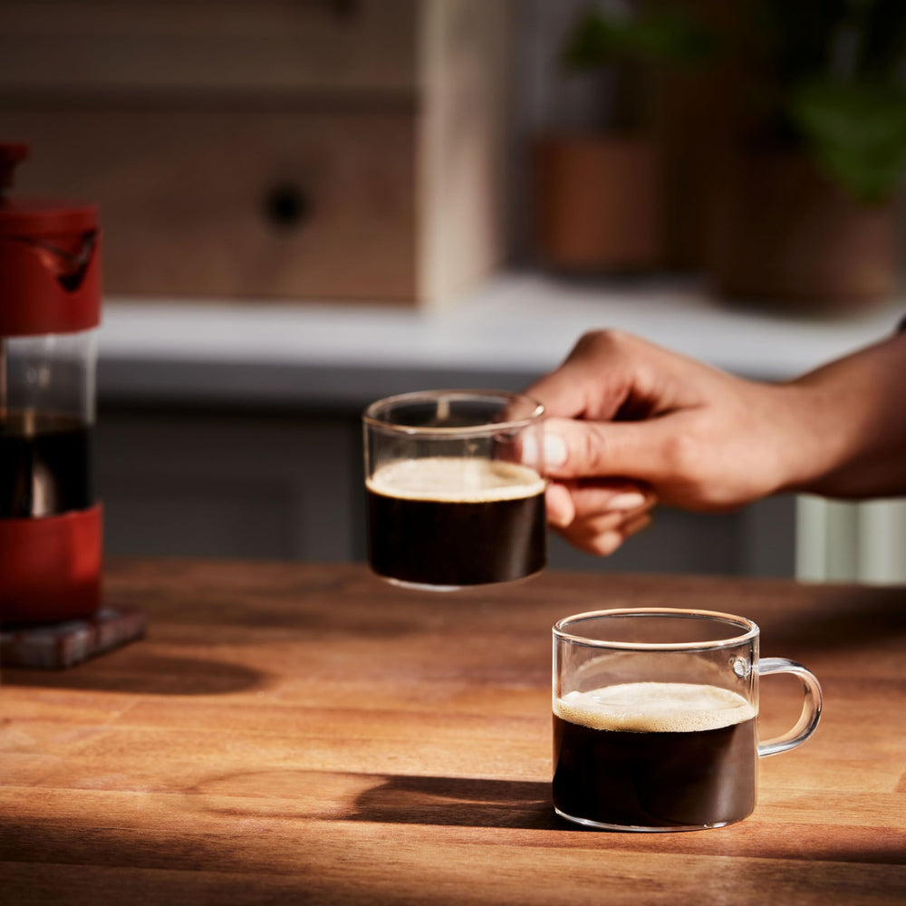 Folgers pods beside a cup for scale and portion clarity