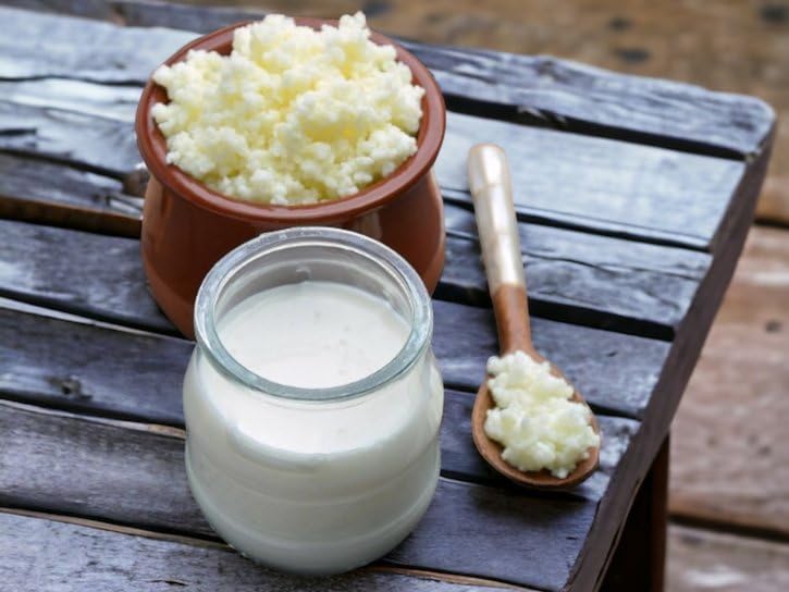 Generic milk kefir poured into glass cup benefit: shows creamy, drinkable result
