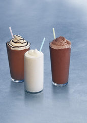 Ghirardelli 50-ounce can beside a hand and cup, demonstrates size and yield benefit
