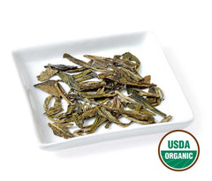 Golden Moon Tea brewed cup showing bright green liquor and clear color