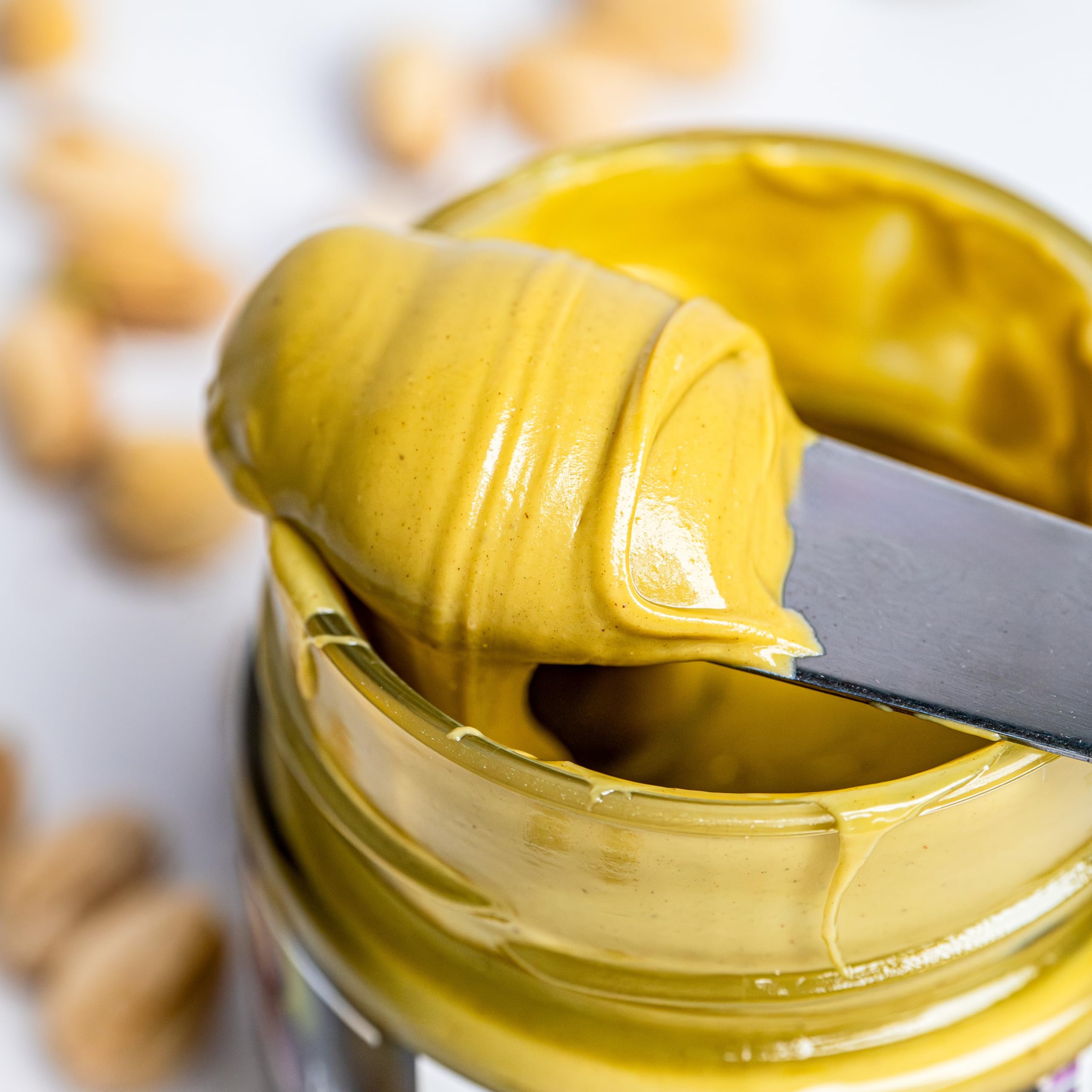 Bowl of whole pistachios with Gourmanity jar conveying real-nut ingredients benefit