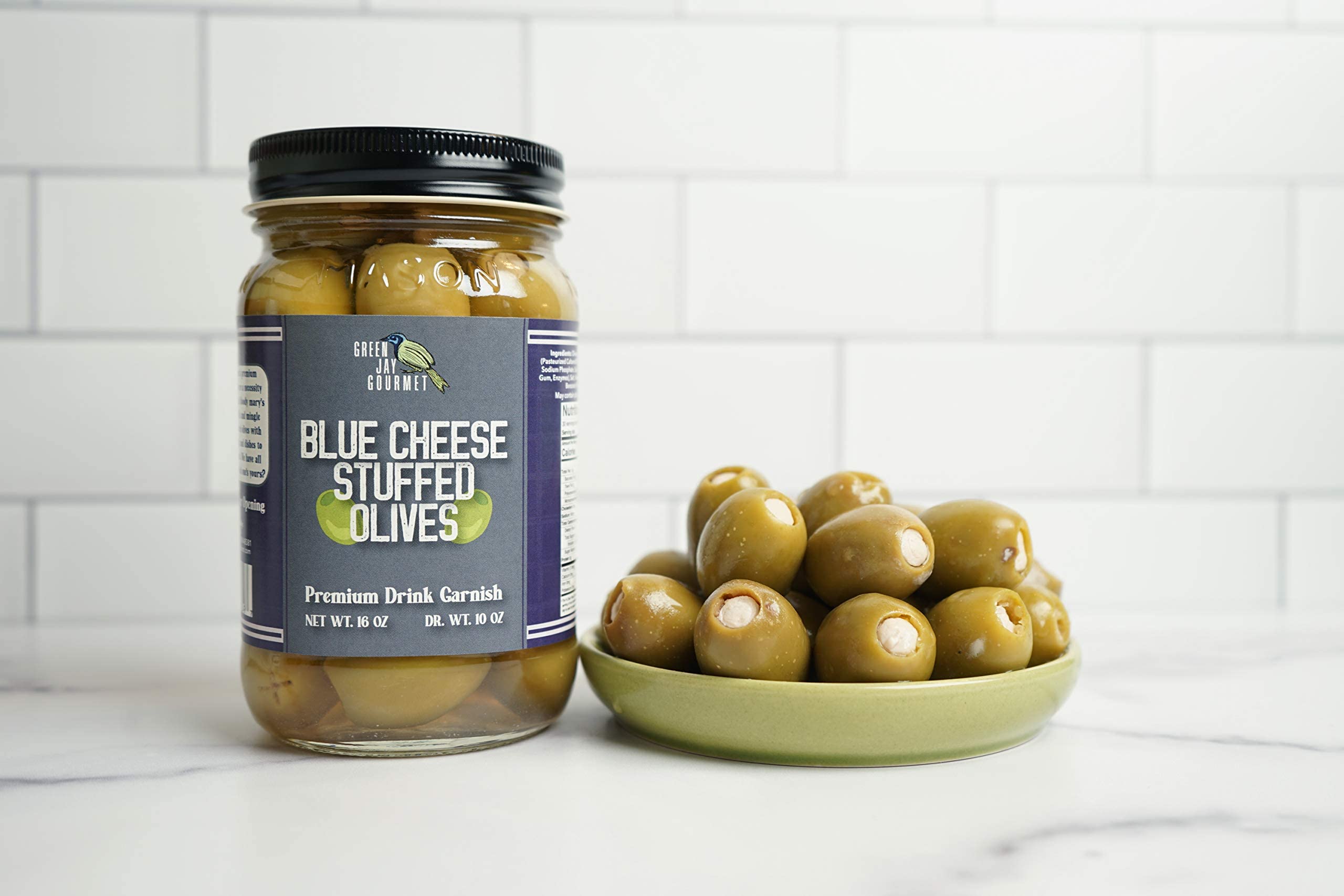 Green Jay Gourmet olives on a cheese board providing savory contrast and visual appeal