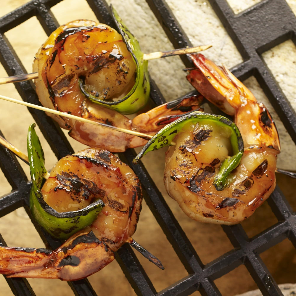 Spread of citrus, garlic, chili and cilantro ingredients behind Grill Mates packet clarifying composition