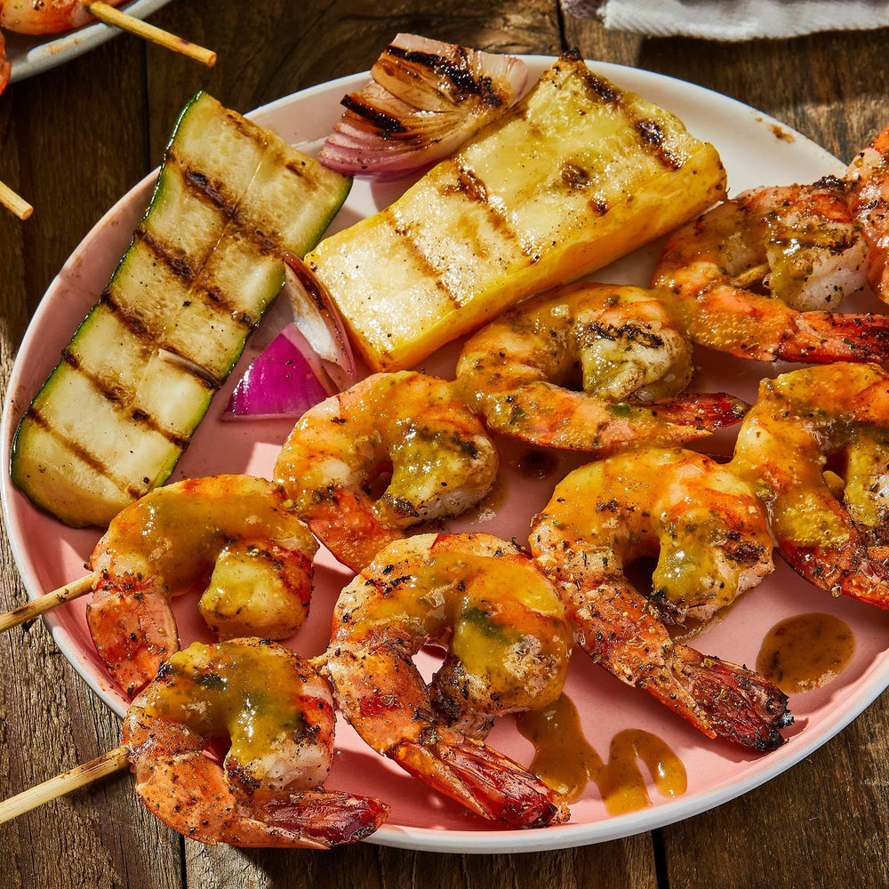 Family enjoying backyard meal with Grill Mates seasoned dishes highlighting social cooking