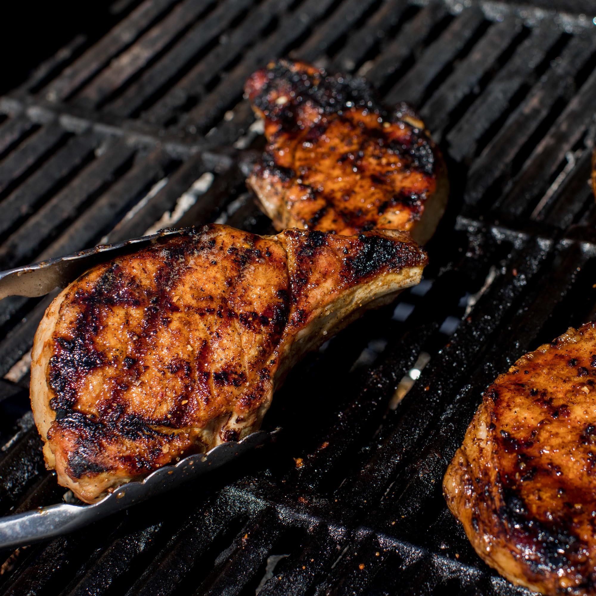 Ten Grill Mates shakers arranged on a grill-side prep table for convenience