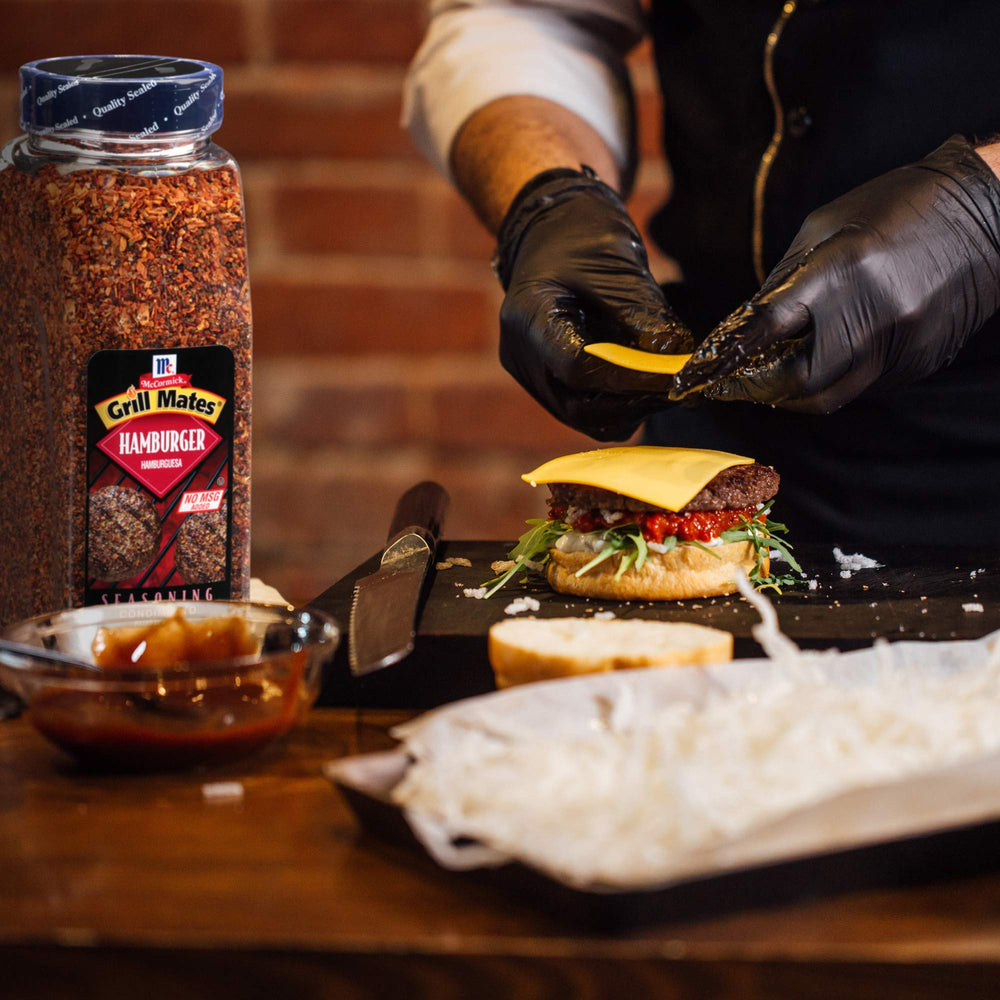 Grill Mates next to hand for scale showing the 24 oz size suitable for busy kitchens