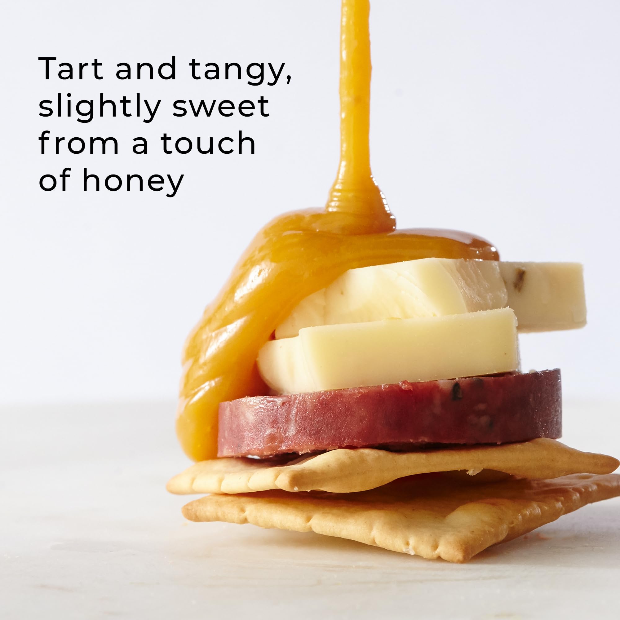 Hickory Farms spread on cracker next to cheese, adds fruity sweetness