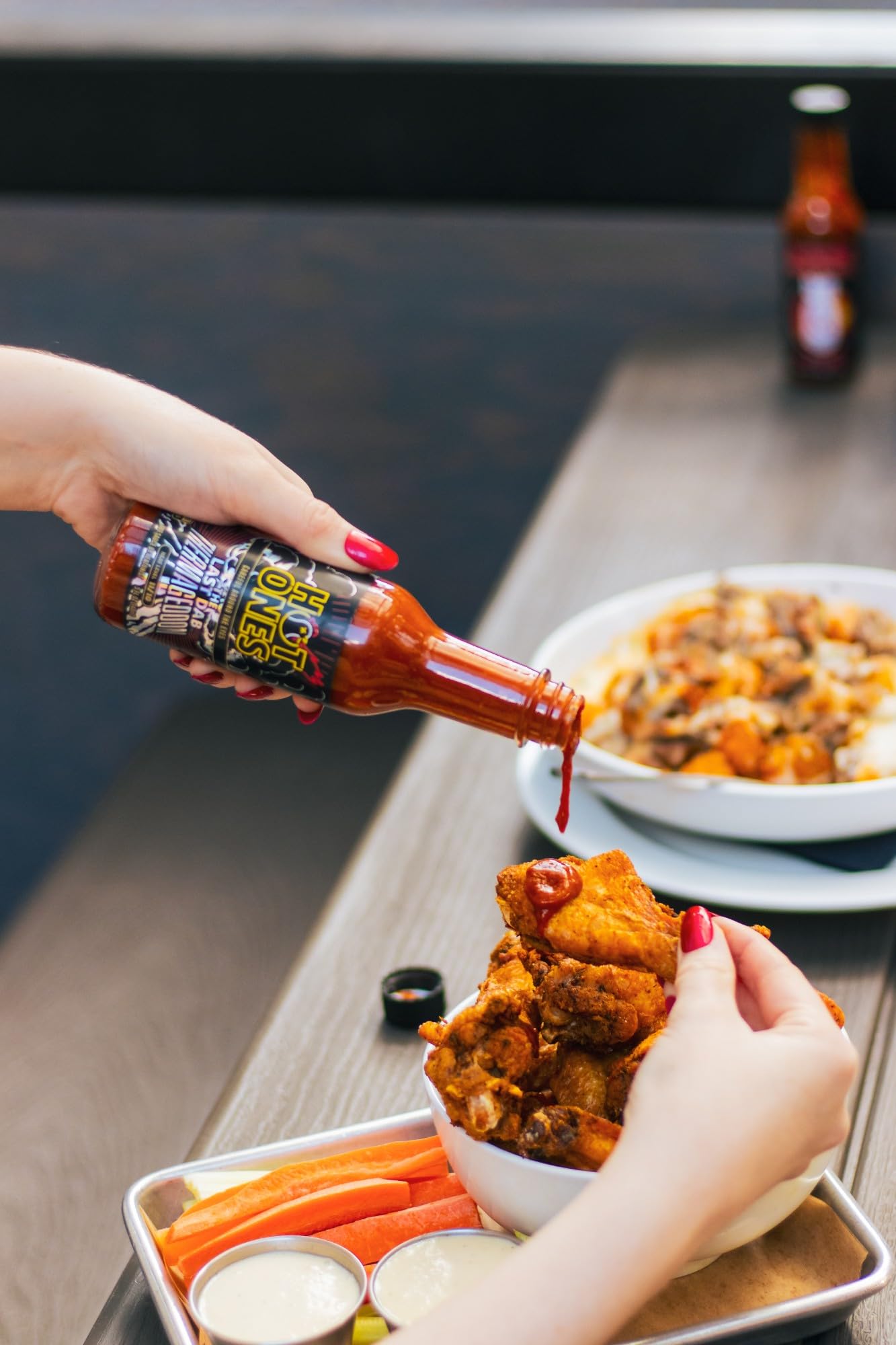 HOT ONES POG bottle beside fruit bowl showing tropical flavor pairing
