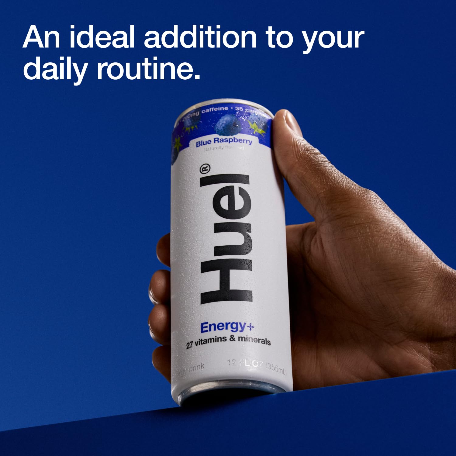 Huel Energy+ blue raspberry can held in hand showing slim size and portability