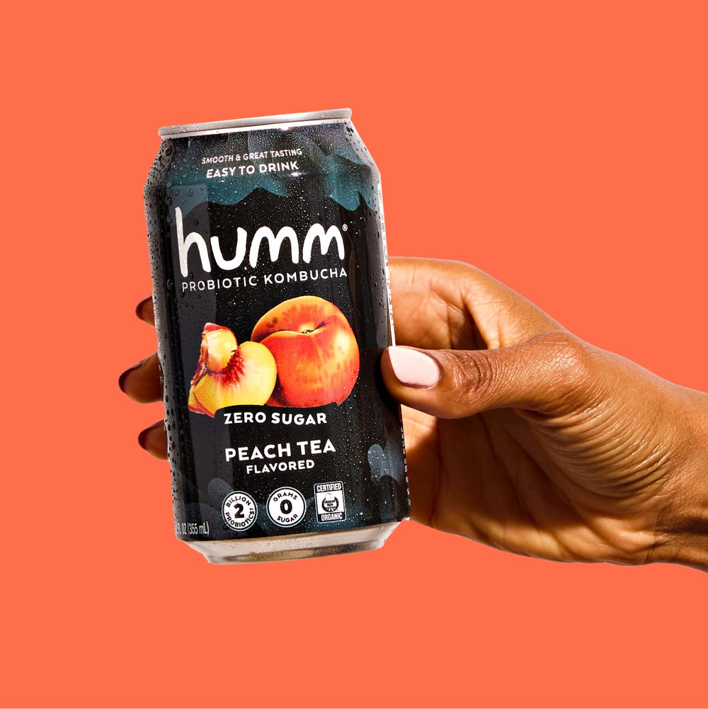 Humm can held in hand showing 12oz scale, convenient portable probiotic beverage