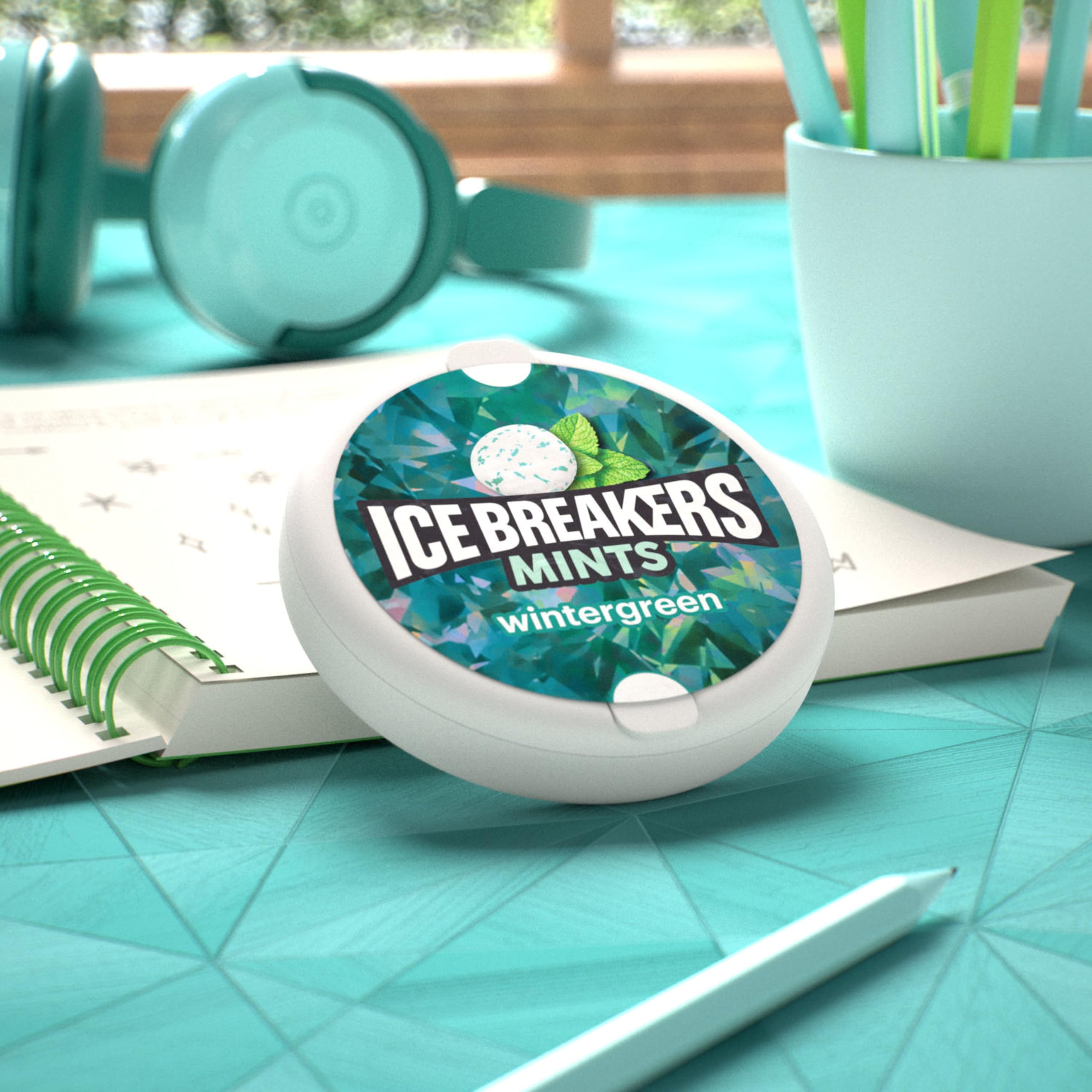 Ice Breakers tin beside a coin for scale indicating compact travel-friendly size