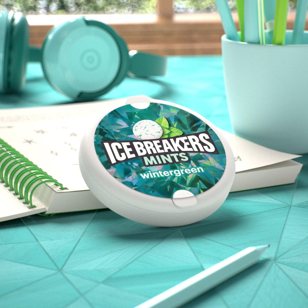 Ice Breakers tin beside a coin for scale indicating compact travel-friendly size
