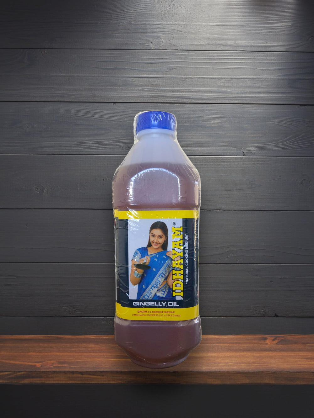 Pouring Idhayam sesame oil from bottle into pan demonstrating controlled pouring and use
