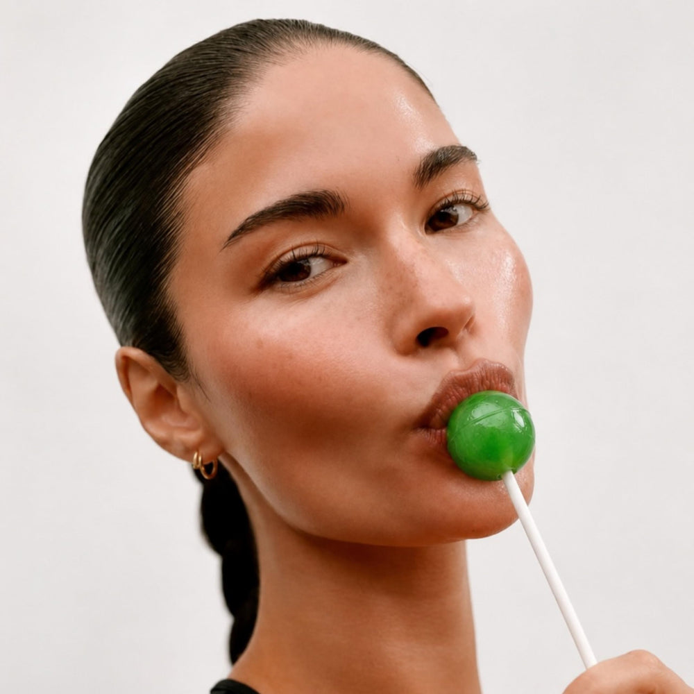 It Girl Vitamins Glow Pop beside a coin showing compact, pocketable size