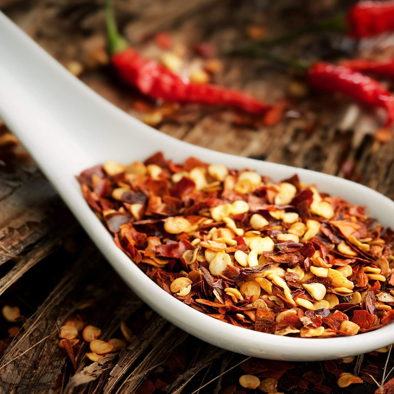 It's Delish flakes sprinkled on pizza slice, adding immediate heat and visual appeal