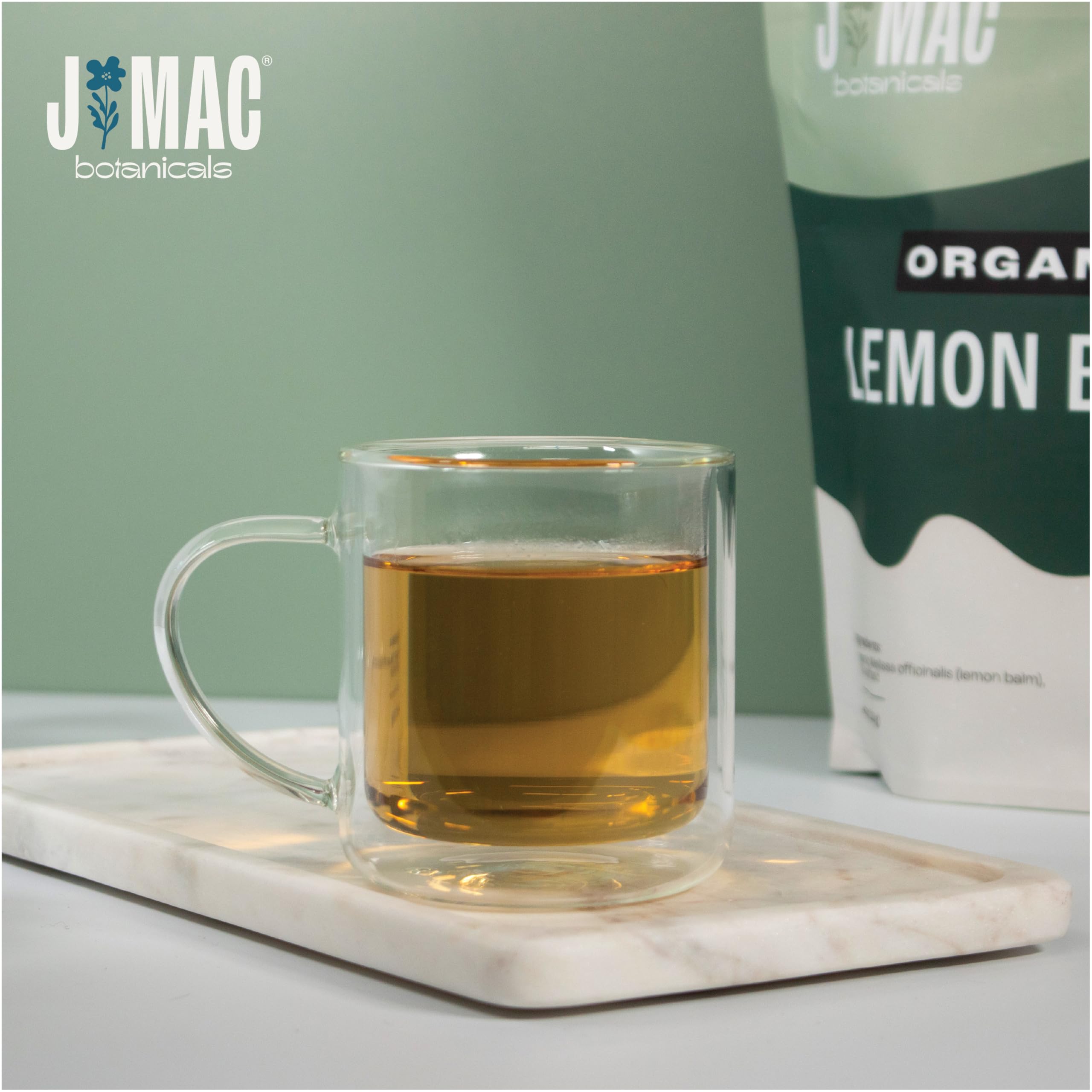 J Mac Botanicals steaming cup of lemon balm tea showing soothing aroma