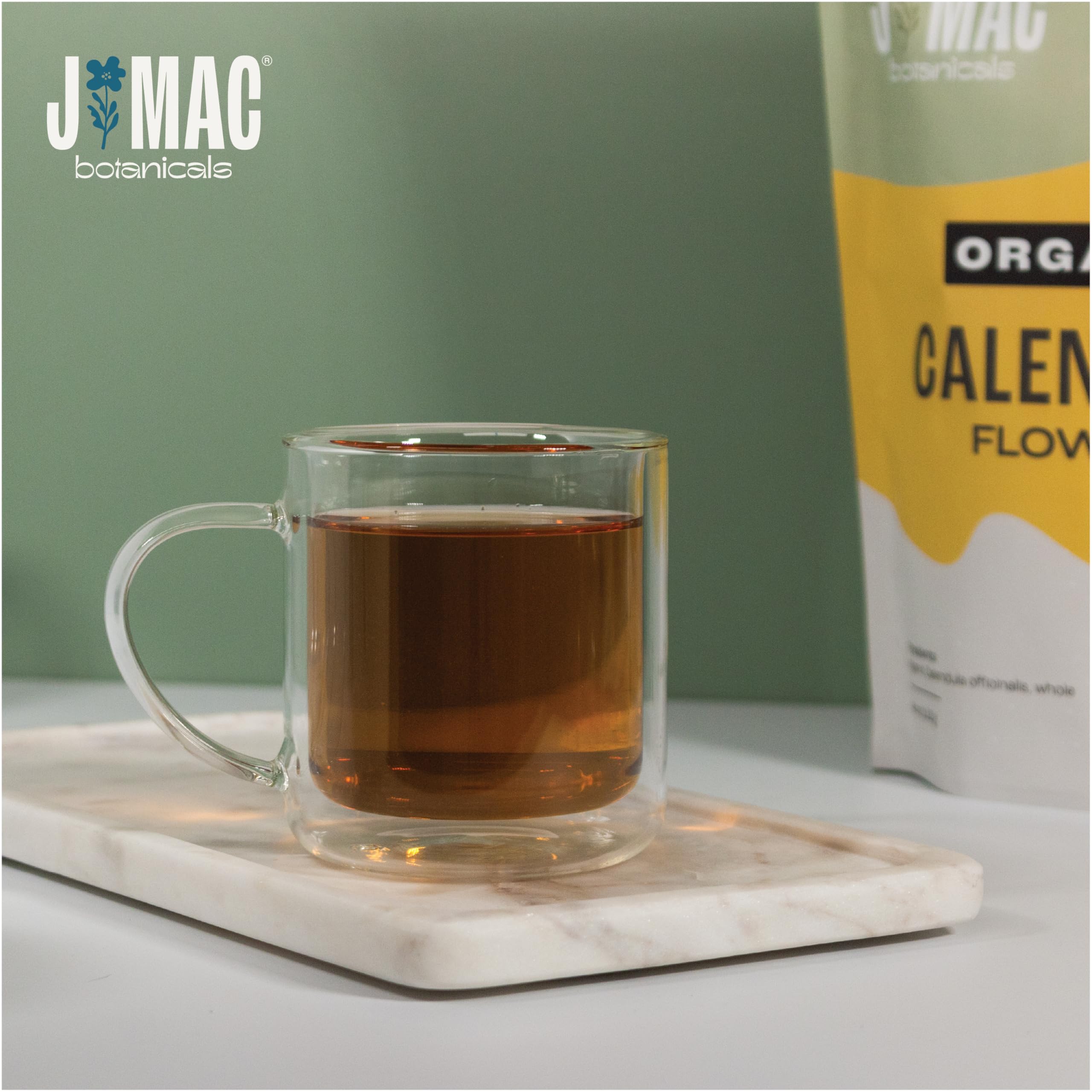 J Mac Botanicals calendula steeping in a glass cup illustrating gentle floral tea infusion