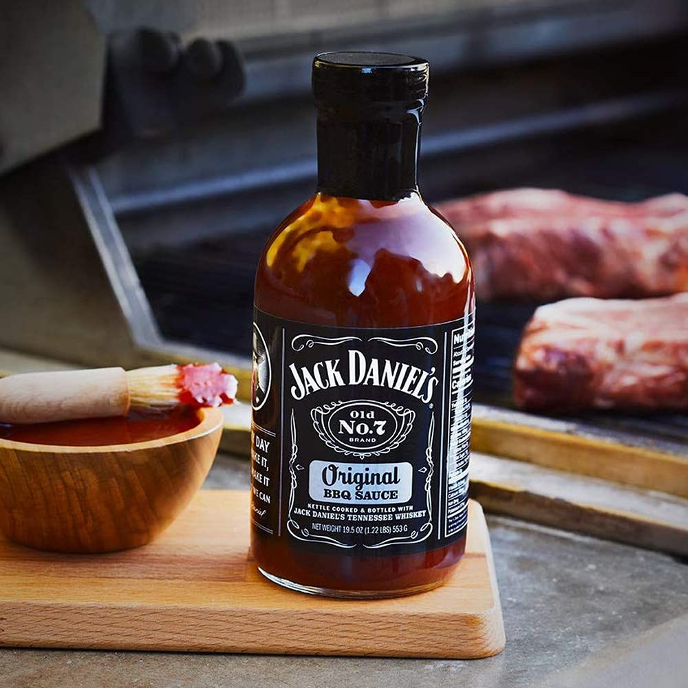 Jack Daniel's Old No.7 bottle in use brushing sauce on ribs for rich flavor finish