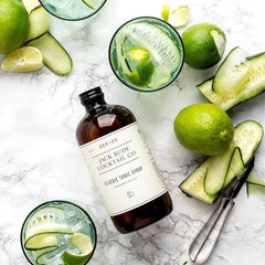 Jack Rudy bottles beside a lemon and jigger to show scale and serving size for home bars