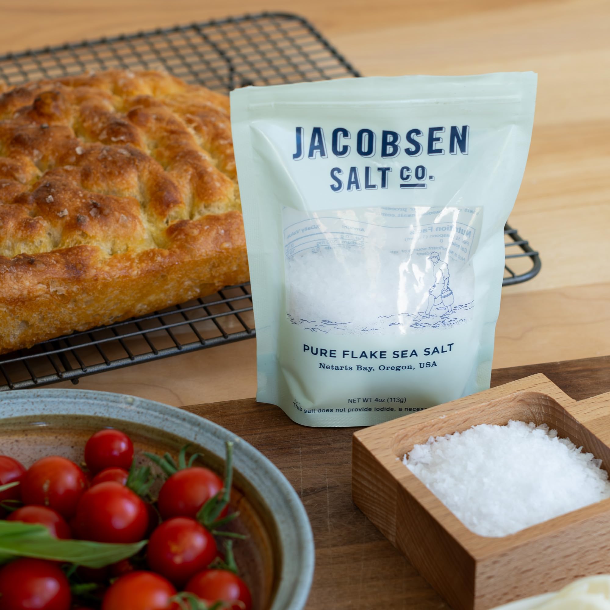 Jacobsen Salt Co. spoon with flakes on a table demonstrating easy seasoning benefit