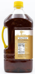 Jiva Organics sesame oil 3 liter bottle next to a measuring cup for scale and value