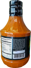 Johnny's dressing being poured onto cooked wings delivering sticky zesty flavor
