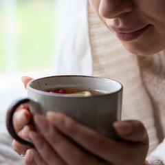 Brewed sarsaparilla tea poured into cup with Jovvily root nearby, demonstrating easy home infusion