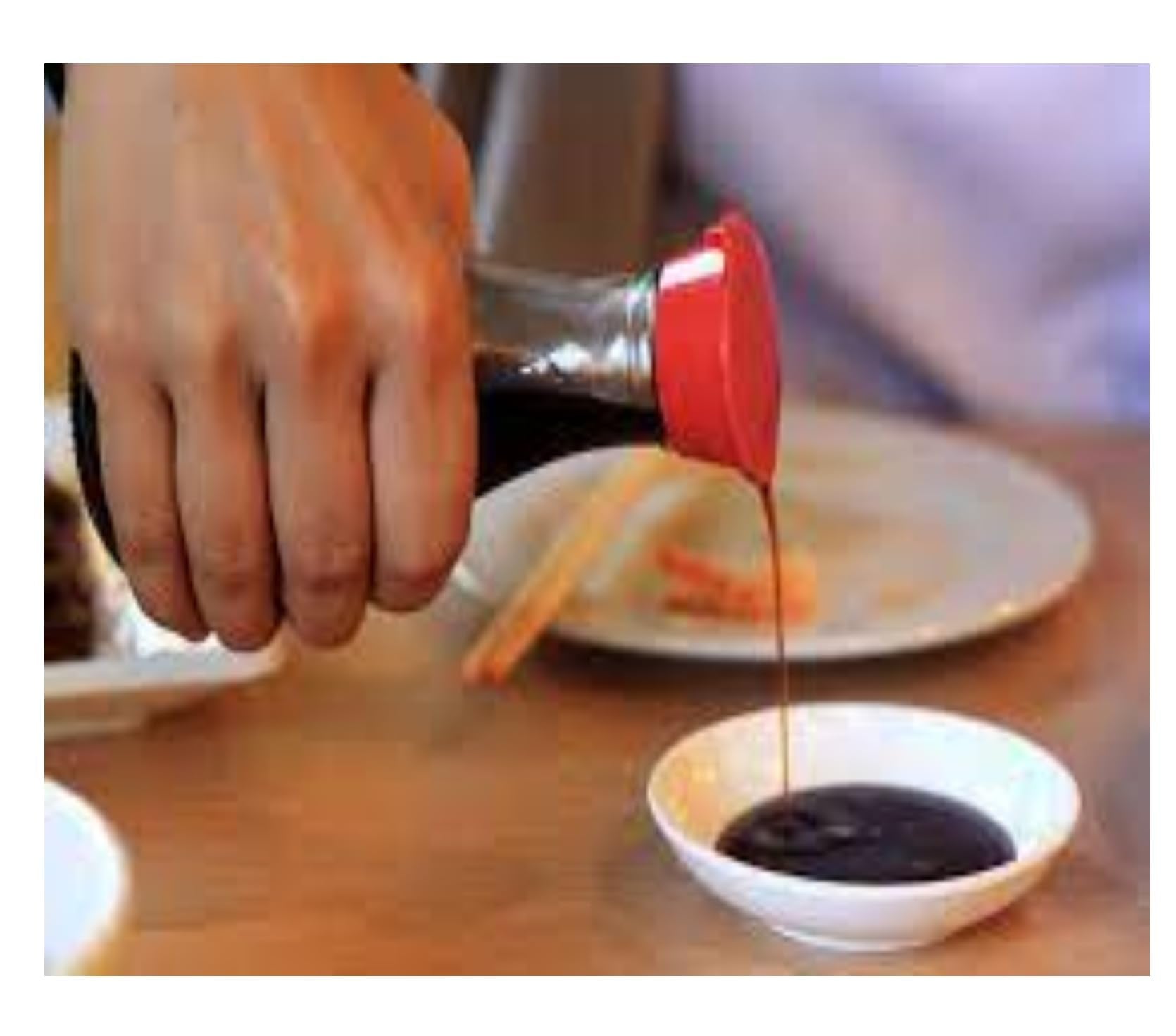 Kikkoman bottle held in hand for size comparison showing practical kitchen portioning