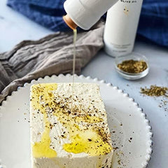 Kosterina garlic oil drizzled on salad enhancing savory finishing flavor