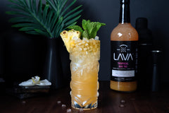LAVA bottle next to rum bottle for scale showing 1-liter glass size and premium look