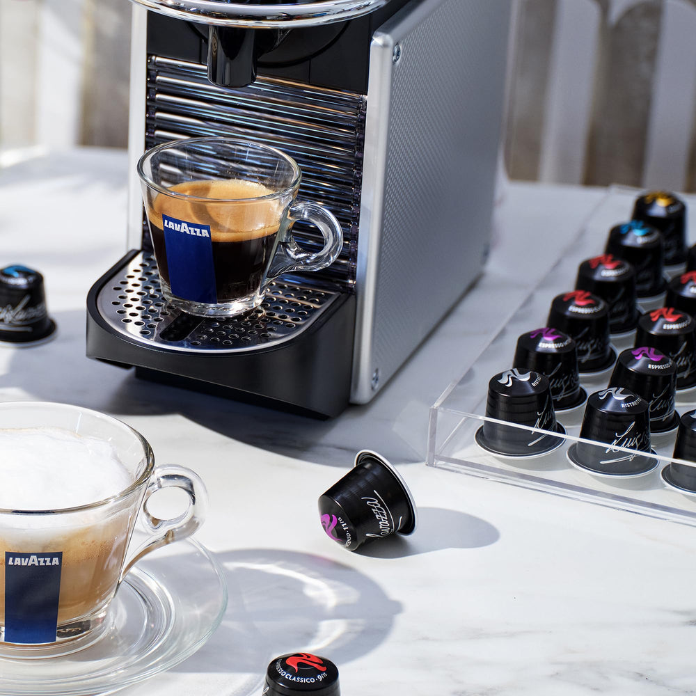 Lavazza capsule displayed next to an espresso cup showing real-world size comparison