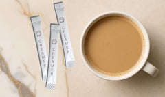 Le Must creamer dissolving in hot coffee cup, showing smooth non-dairy whitening and fast blend