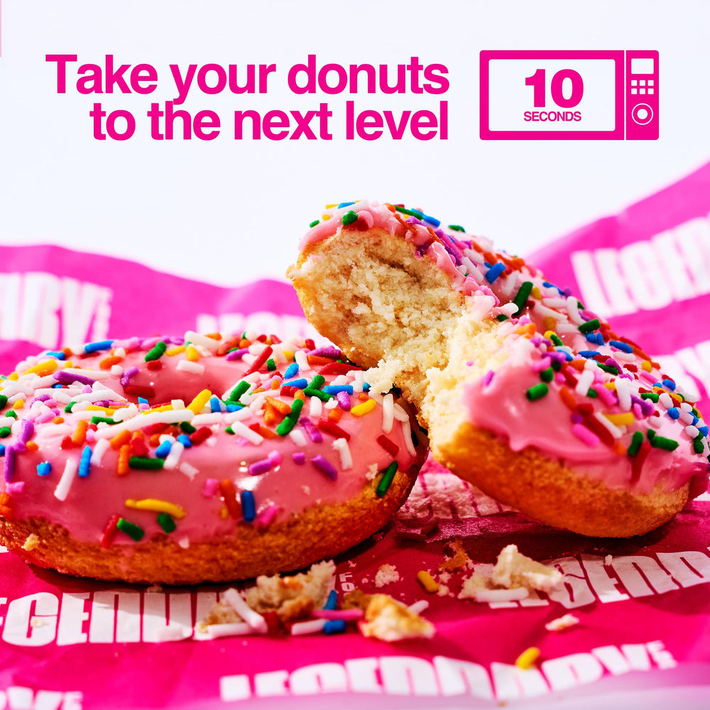 Legendary Foods warmed pink sprinkle donut on plate with melted glaze