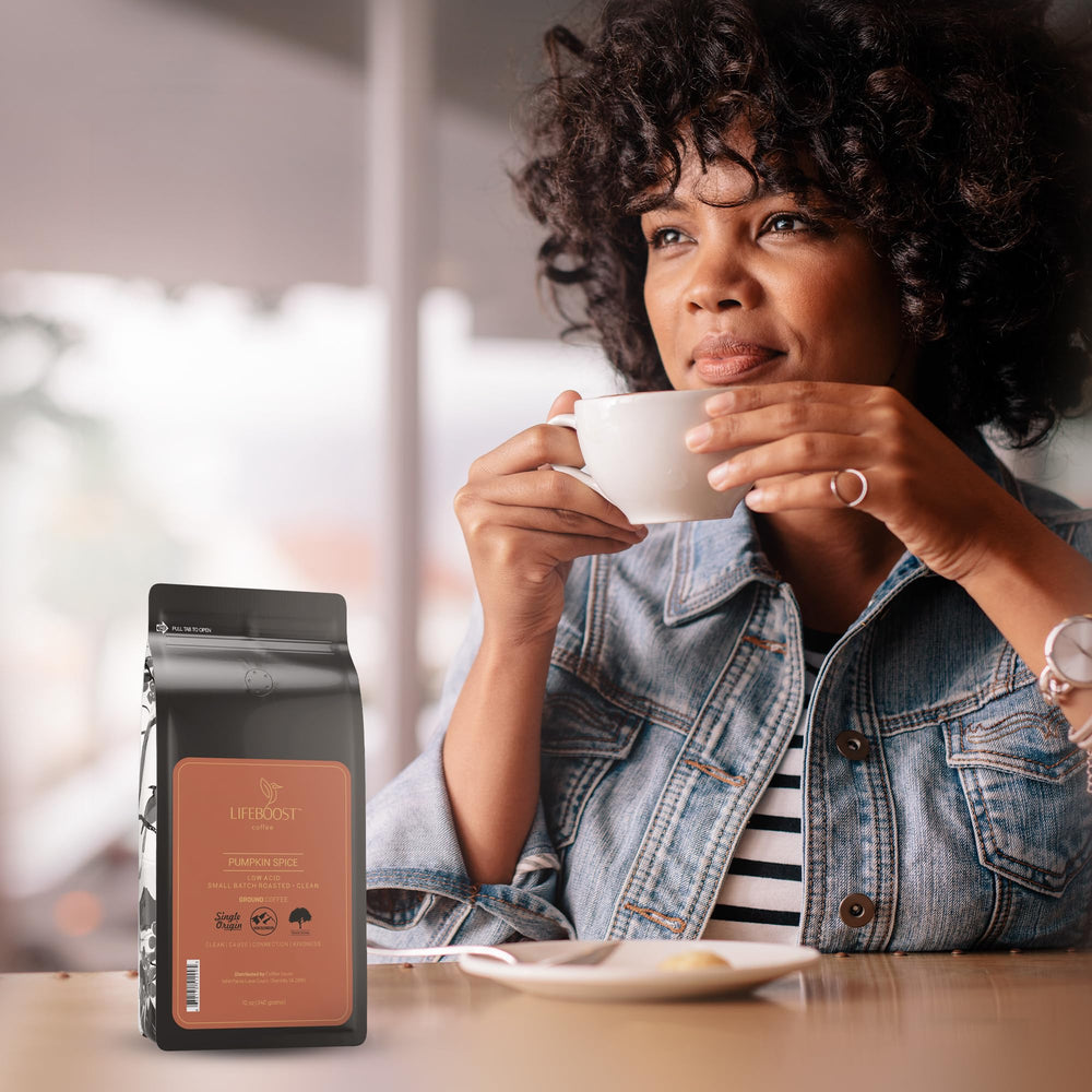 Lifeboost measuring ground coffee on a spoon and scale, demonstrating precise brewing and portioning