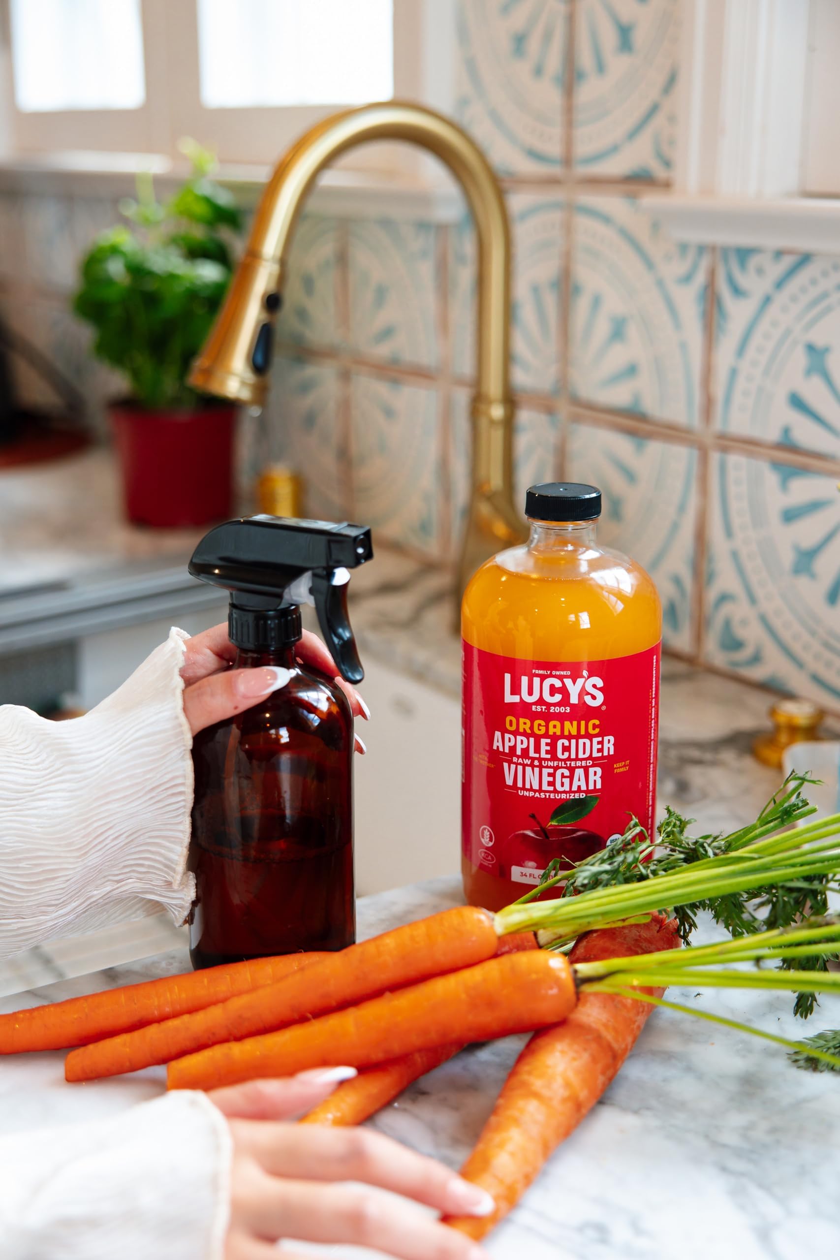 Two Lucy's glass bottles in a lifestyle scene suggesting pantry readiness and family-owned origin