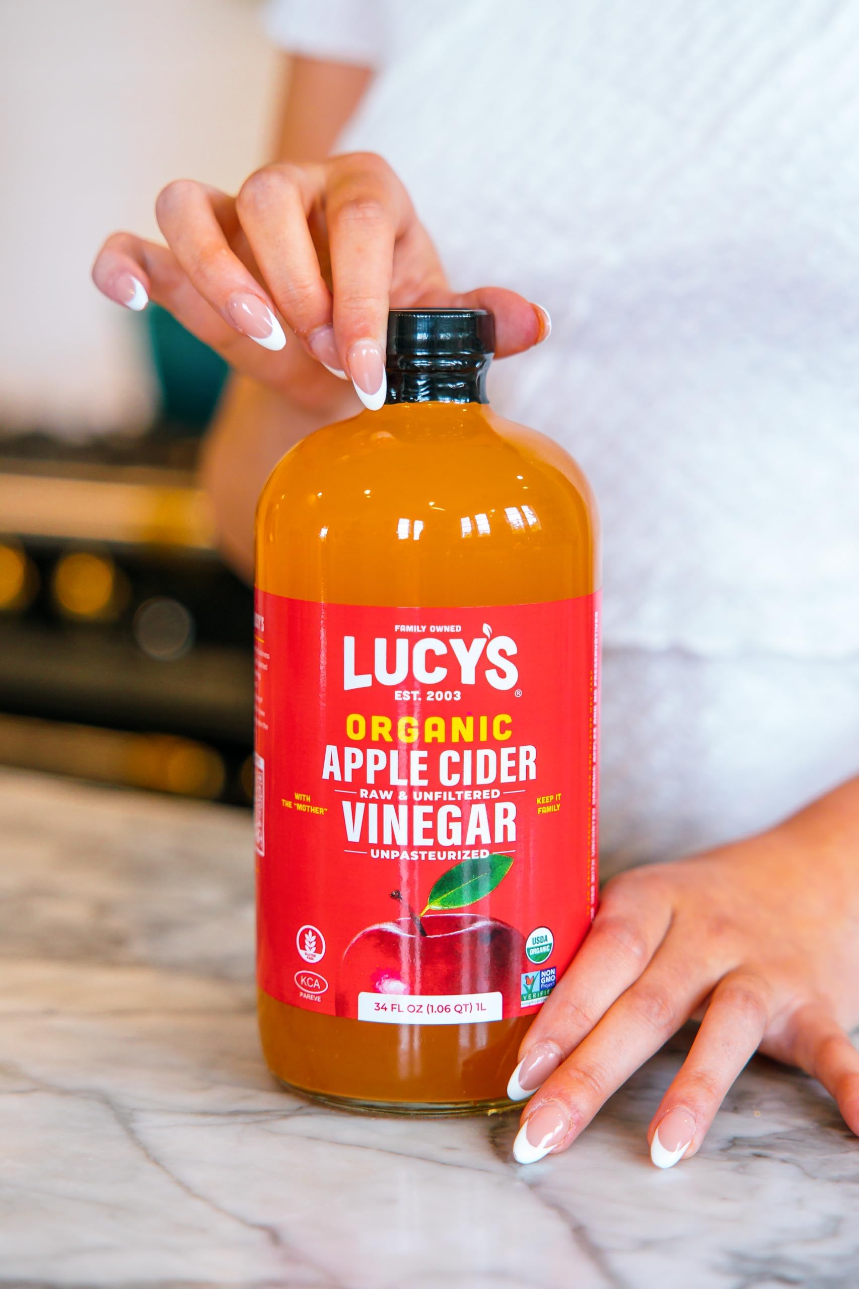 Pouring Lucy's into a salad dressing to demonstrate easy mixing and mellow 5% acidity flavor