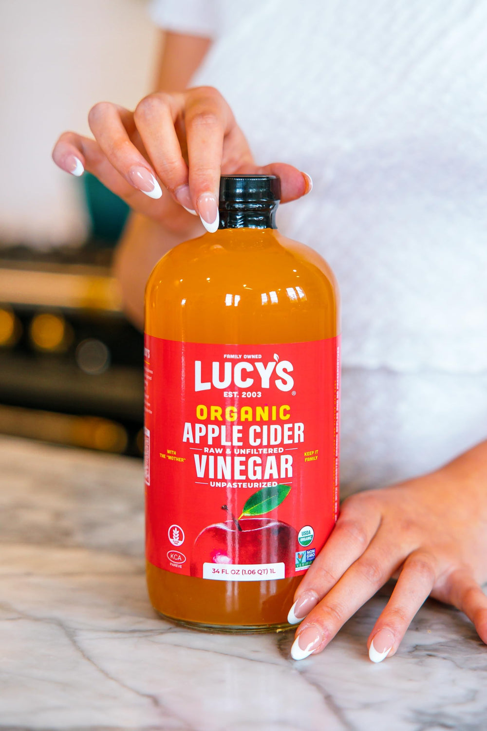 Pouring Lucy's into a salad dressing to demonstrate easy mixing and mellow 5% acidity flavor