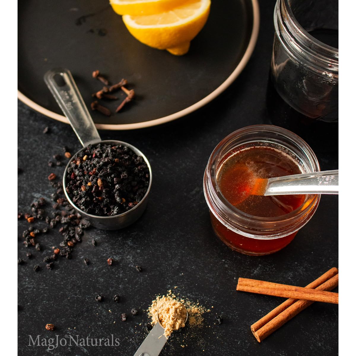 MagJo elderberries on wooden spoon ready for cooking to add rich flavor