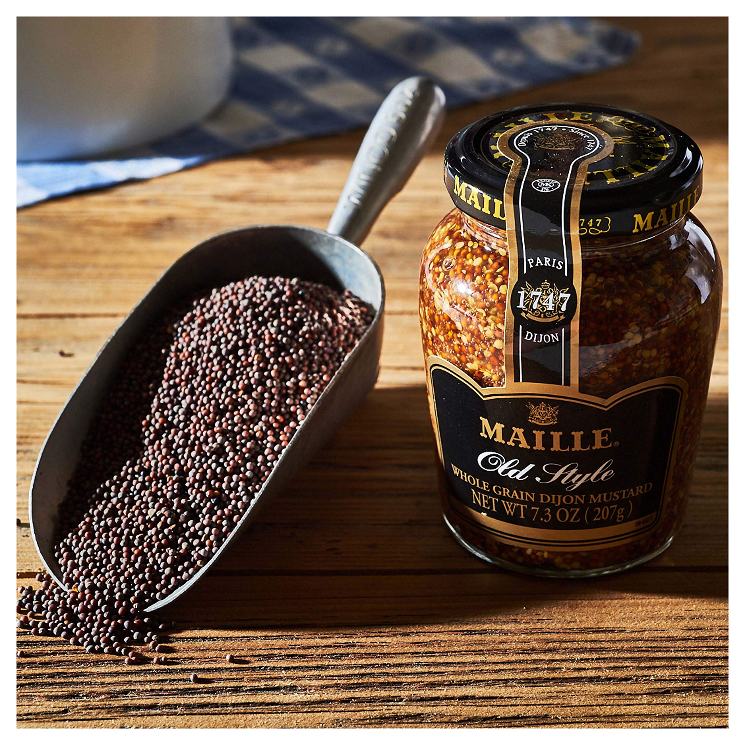 Maille Old Style jar in hand showing 7.3 oz scale for portion reference