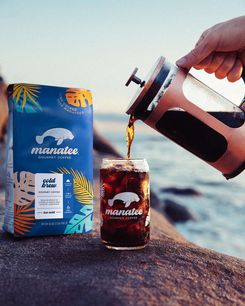 Iced cold brew in a lifestyle setting with Manatee Gourmet packaging, showing refreshment appeal