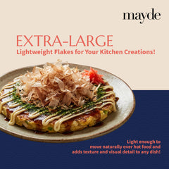 Mayde flakes sprinkled on okonomiyaki, demonstrating visual movement and enhanced taste benefit