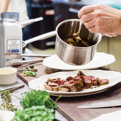 McCormick Culinary being sprinkled on steak to improve tenderness and cook consistency