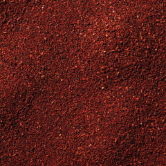 close-up spoon of McCormick dark chili powder showing coarse texture and aroma benefit