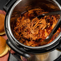 McCormick seasoning mixed with pork in slow cooker for tender shredding