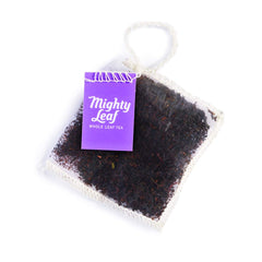 Mighty Leaf sachet steeping in mug producing deep amber color for strong morning cup