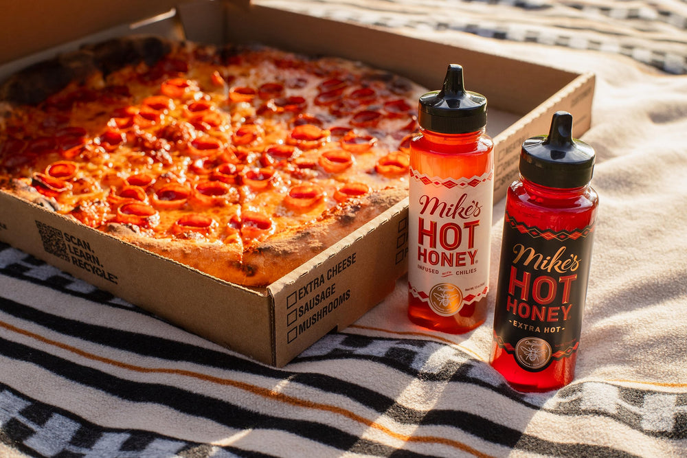 Mike's Hot Honey being poured over pizza showing instant sweet-heat enhancement
