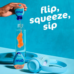Close-up of MiO Peach Mango drop on fingertip showing concentrated texture and easy dosing
