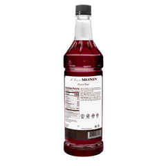 Monin Desert Pear pouring into glass shows vivid fuschia color and enhances drink presentation