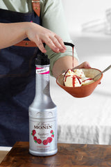 Monin raspberry puree pouring close-up showing seeded texture and vibrant color benefit